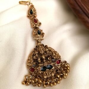 Antique gold finish temple jewellery pendant with ornate deity-inspired motif, red and green stones, intricate traditional detailing and antique gold bead drops | Code MNK 14