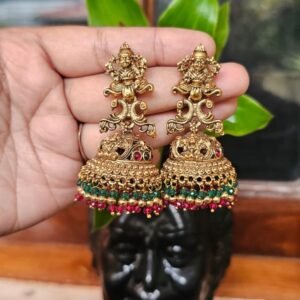 Antique gold temple bridal jhumka earrings with intricate goddess motifs, decorative stones, and green and pink bead drops.
