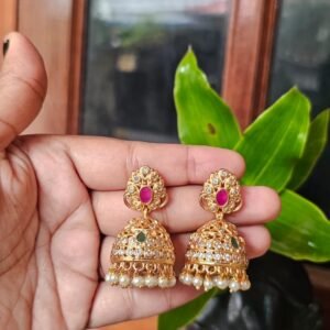 Antique gold AD stone jhumka earrings with white stones, pink and green accents, and white pearl drops.